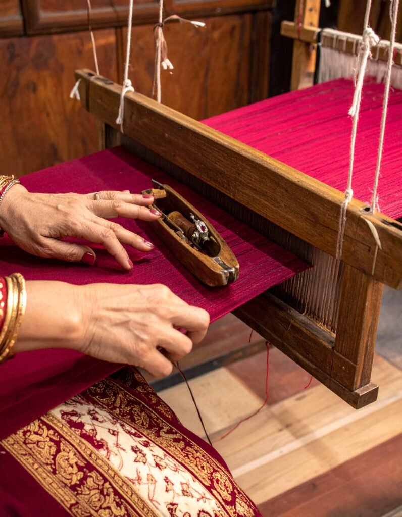 Indian weaver making red color handwoven silk saree