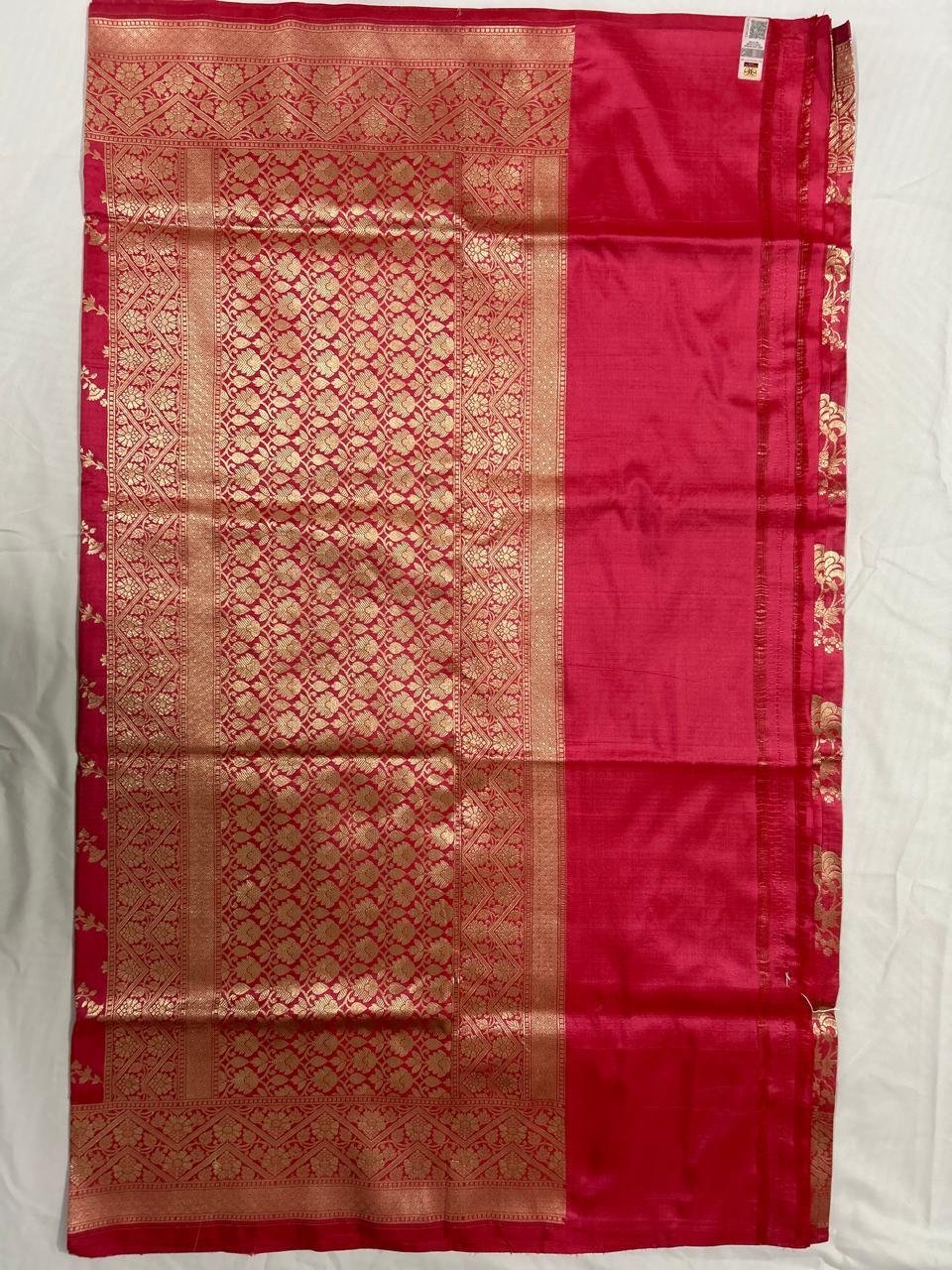 Silk sarees - Uppada Banarasi Saree in vibrant red, this luxurious silk piece features an intricate gold woven border and pallu adorned with traditional floral and geometric patterns. Elegantly laid flat on a white surface, the saree highlights its exquisite craftsmanship.